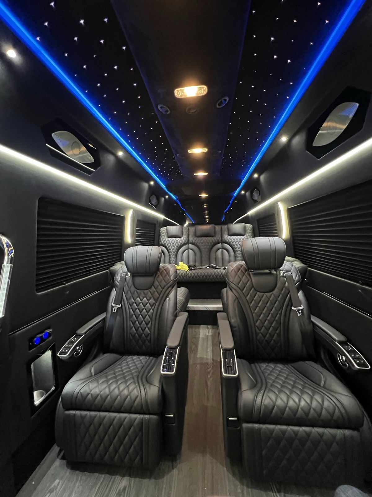 VIP Sprinter aisle with leather captain chairs under a starlight ceiling